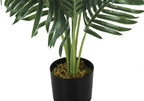 Close-up of an artificial Cat Palm with long green fronds in a simple black pot topped with decorative moss.