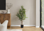 Large faux acacia tree styled in a living room corner beside a couch