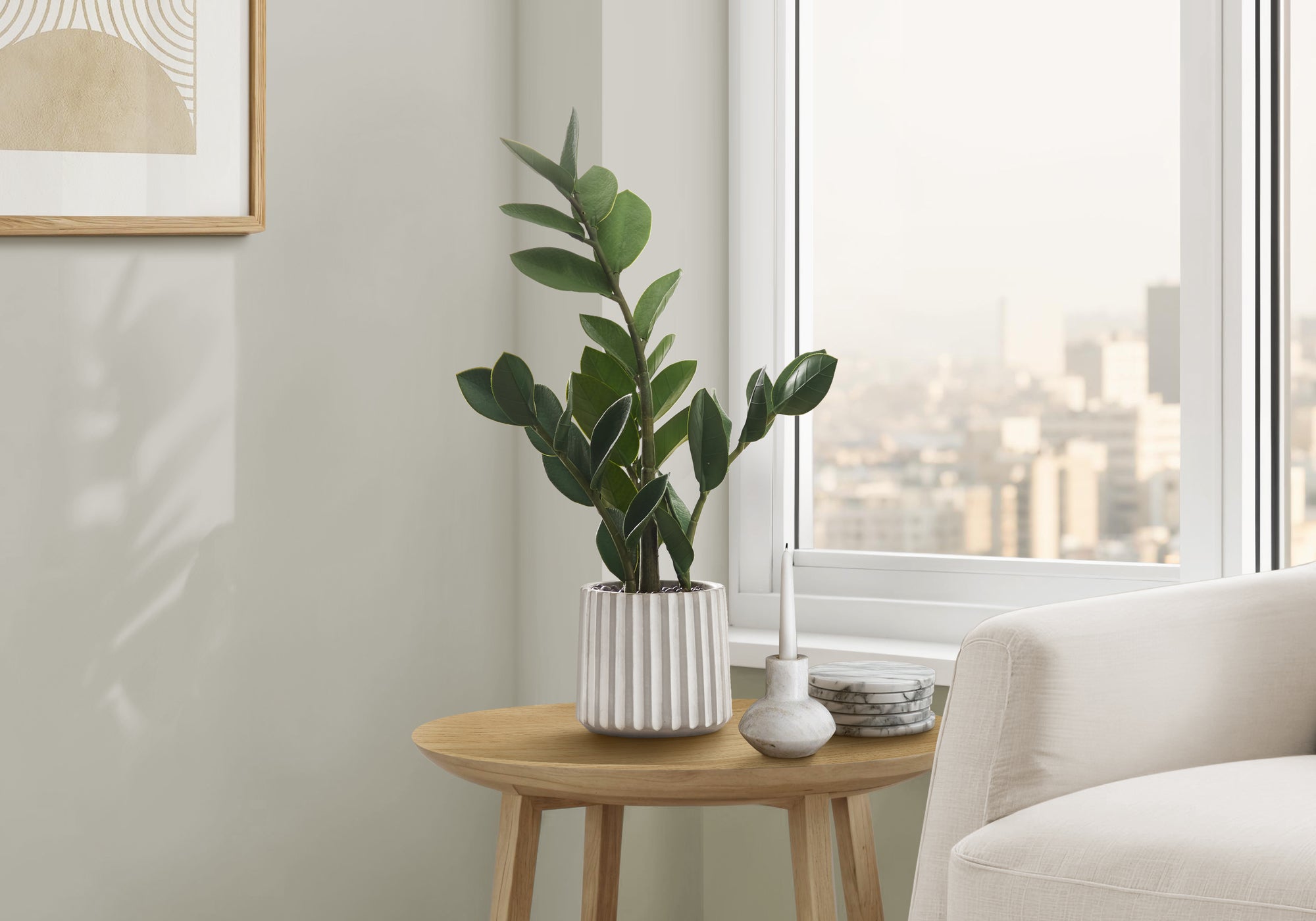 An artificial Small ZZ Plant in a white ribbed pot sits on a wooden side table next to a window.