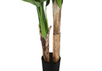Close-up of the dual textured brown trunks and green leaves of an artificial banana plant in a black pot.