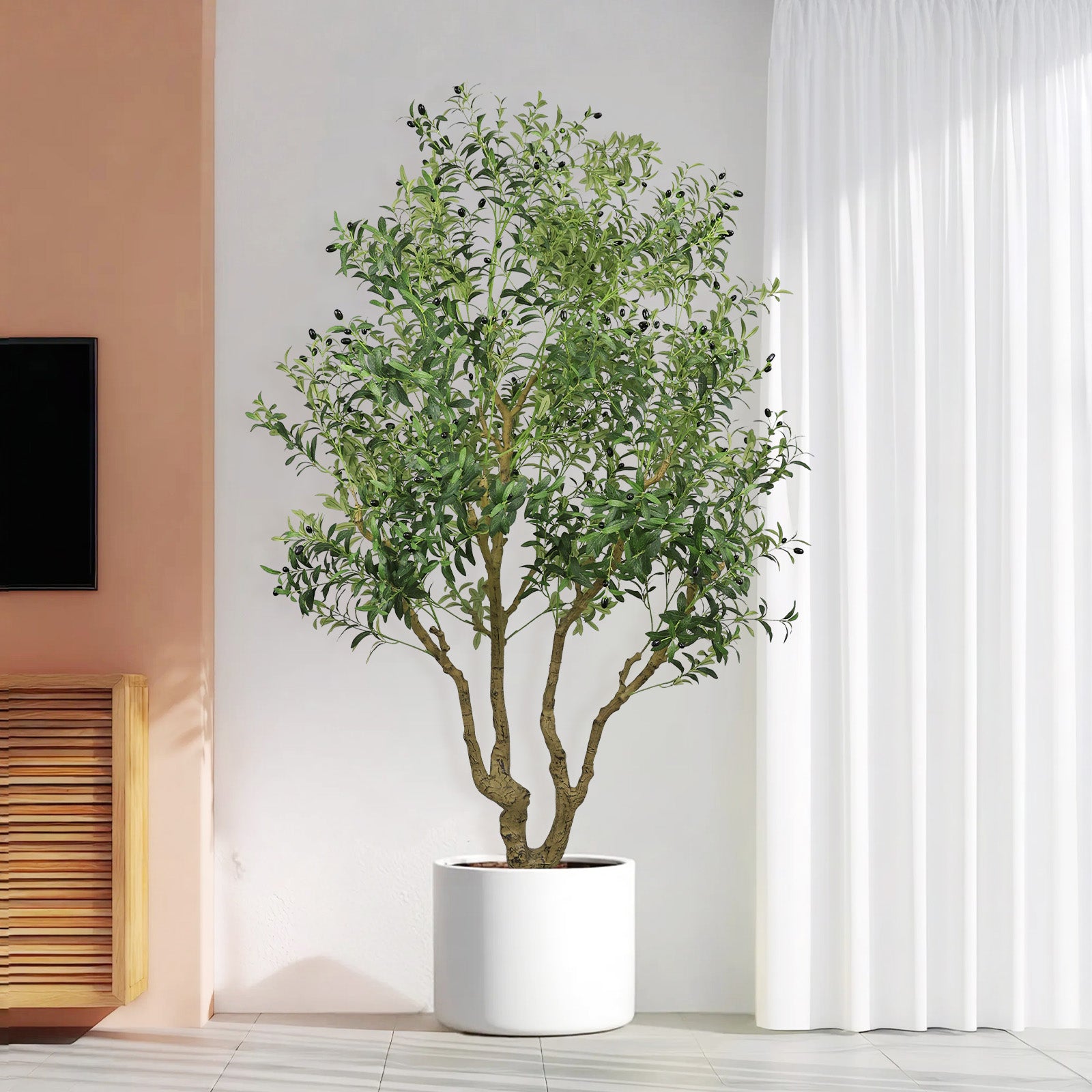 A tall artificial olive tree with green leaves and small black olives in a simple white cylindrical pot.