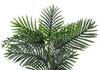 Close-up of the green, feathery fronds of an artificial Areca palm plant against a plain white background.