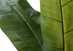 Close-up of two large, textured green leaves from an artificial banana plant showing detailed veins.