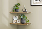 Two artificial plants in patterned black and white pots styled on wooden corner shelves with decor items.