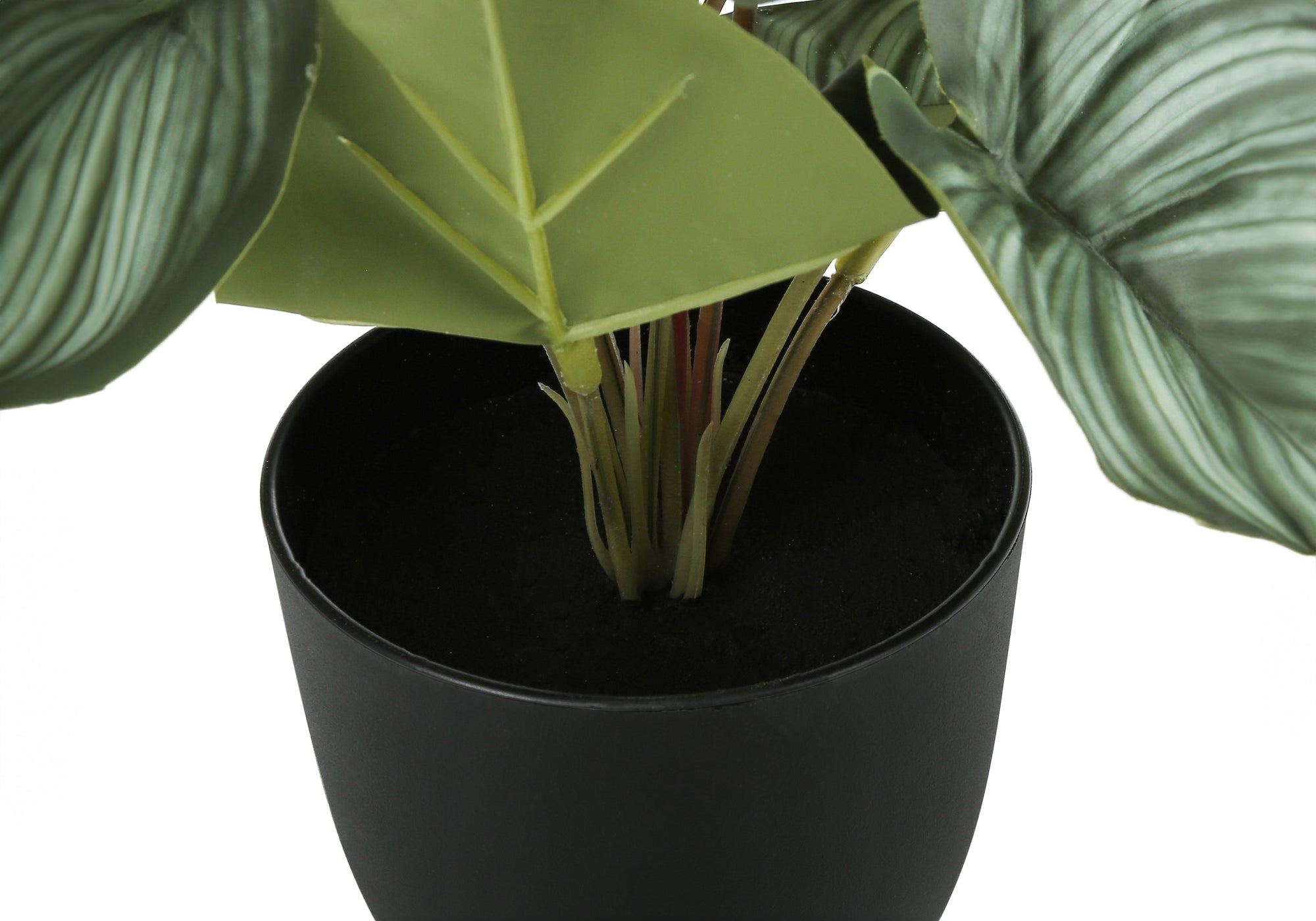 Close-up of an artificial plant with textured green leaves in a simple black pot against a white background.