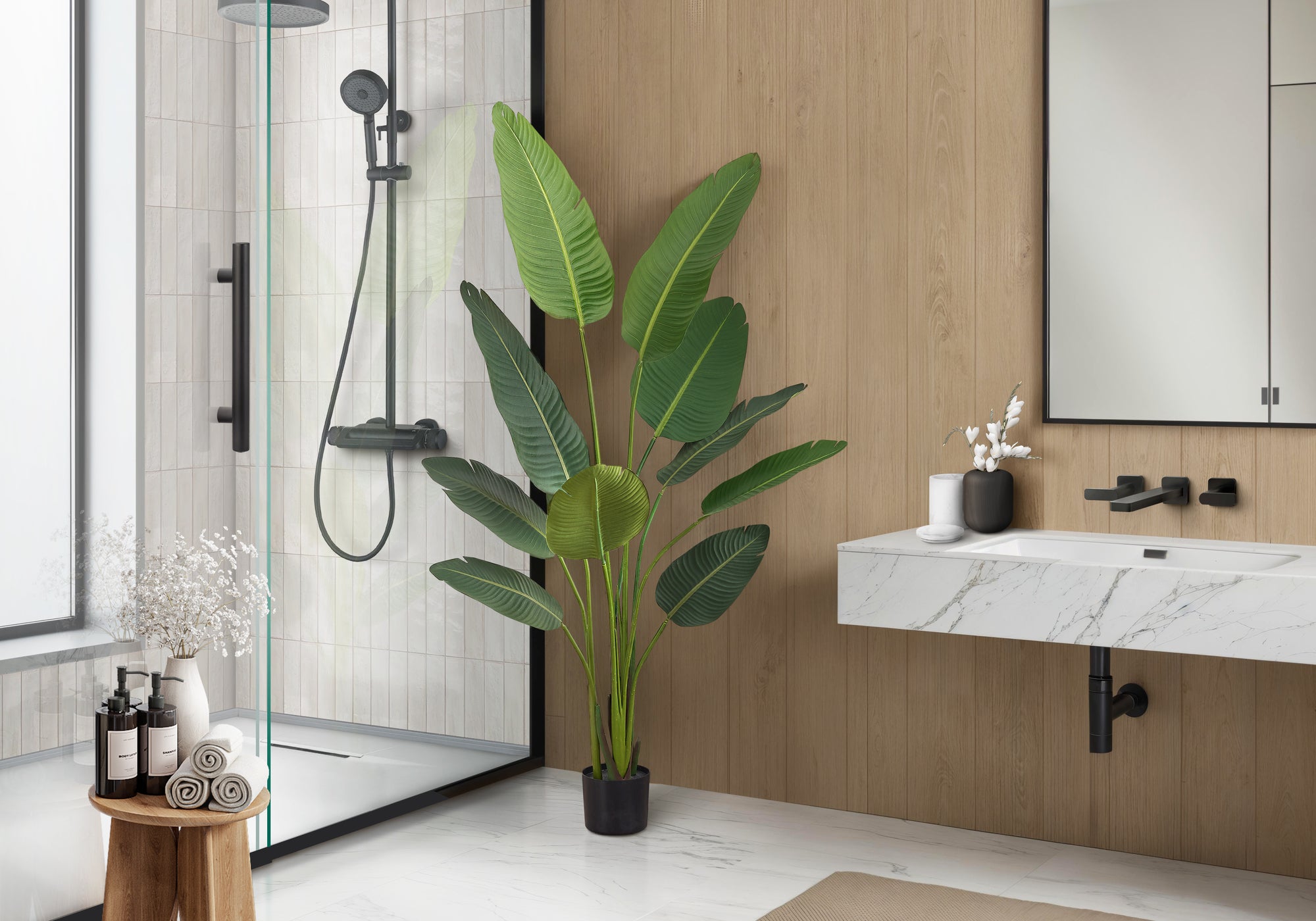 Large faux Bird of Paradise plant styled in a modern bathroom corner beside a shower