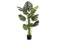 A tall artificial Monstera plant with large split green leaves in a black pot, isolated on a white background.