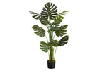 A tall artificial Monstera plant with large split green leaves in a black pot, isolated on a white background.