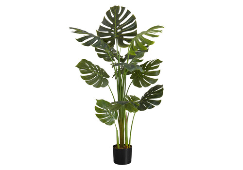 A tall artificial Monstera plant with large split green leaves in a black pot, isolated on a white background.
