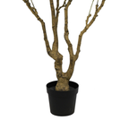 Close-up of the textured, light brown trunk of an artificial ficus tree standing in a simple black plastic pot.