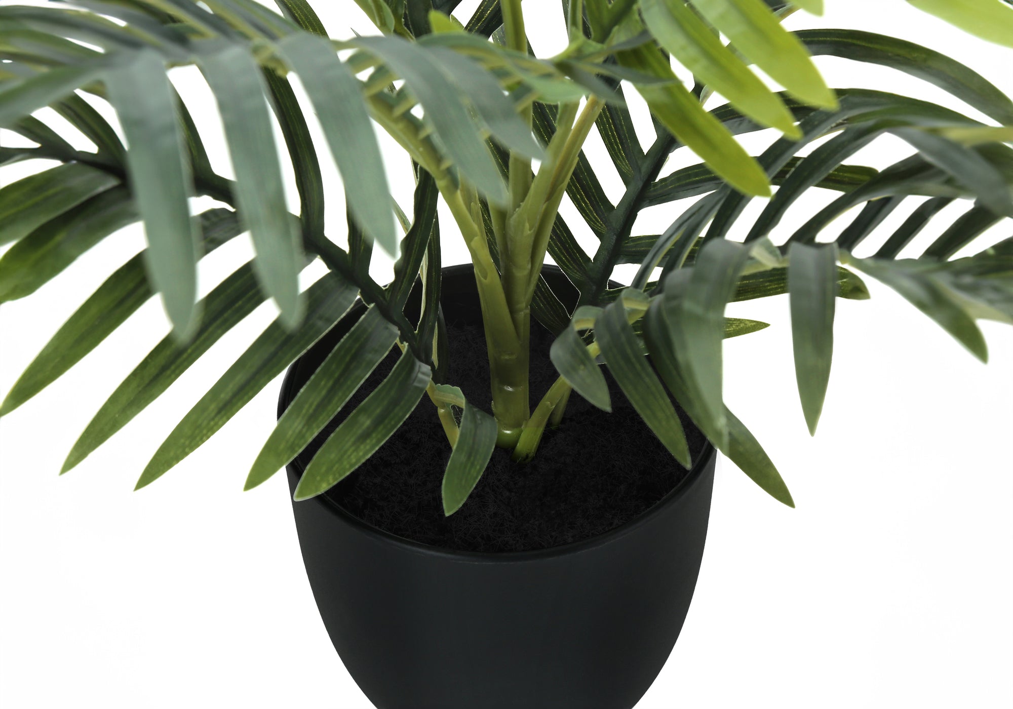 Close-up of an artificial areca palm plant showing green fronds and stems in a simple black pot.