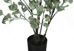 Close-up of an artificial eucalyptus plant with frosted green leaves in a simple black pot against a white background.