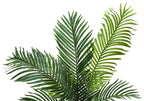 Close-up of the vibrant green, feathered fronds of an artificial Majesty Palm tree against a white background.