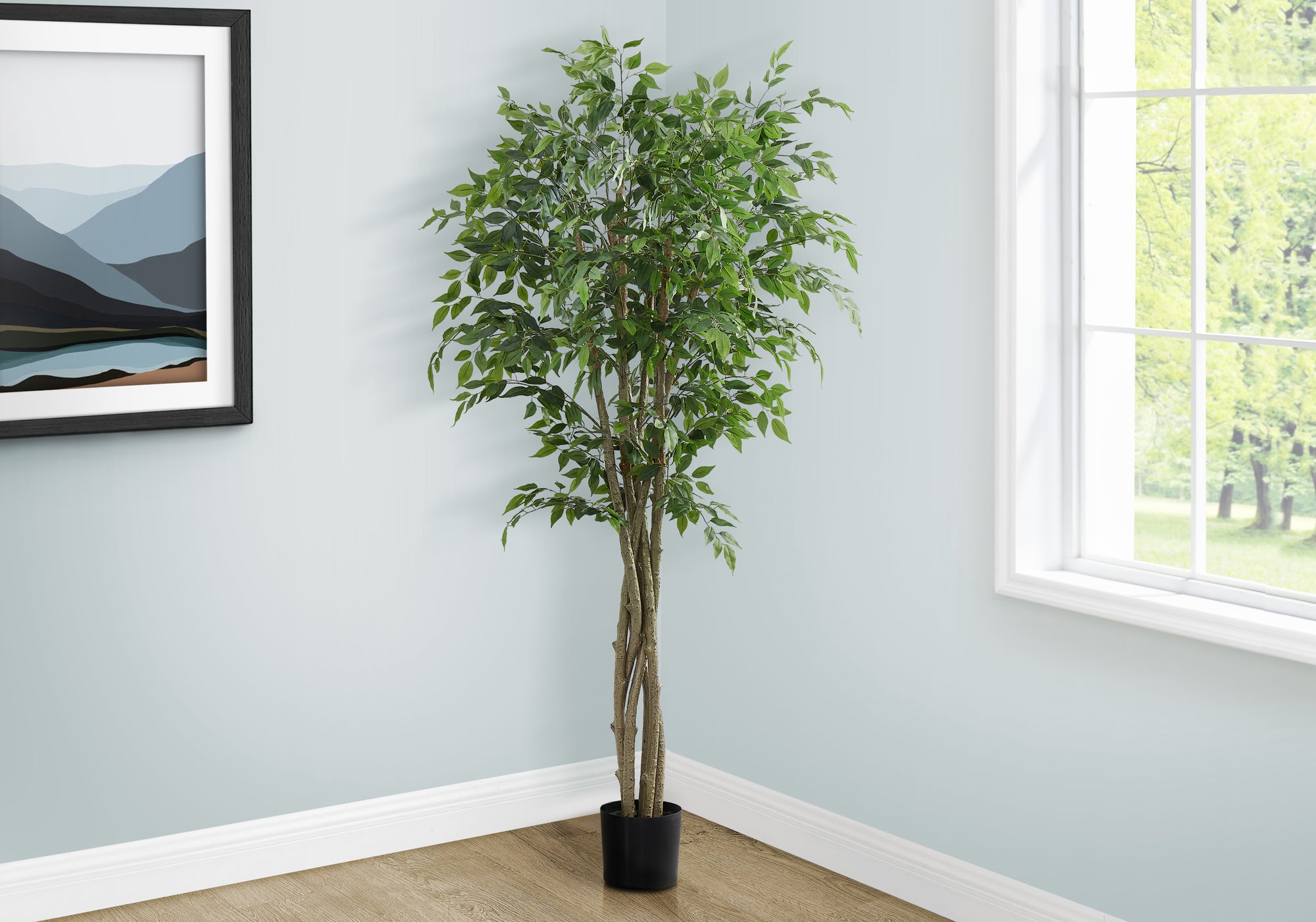 A tall artificial weeping fig tree with a braided trunk stands in a corner next to a window and framed wall art.