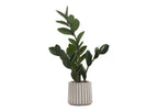 An artificial small ZZ plant with glossy green leaves in a ribbed grey pot against a white background.