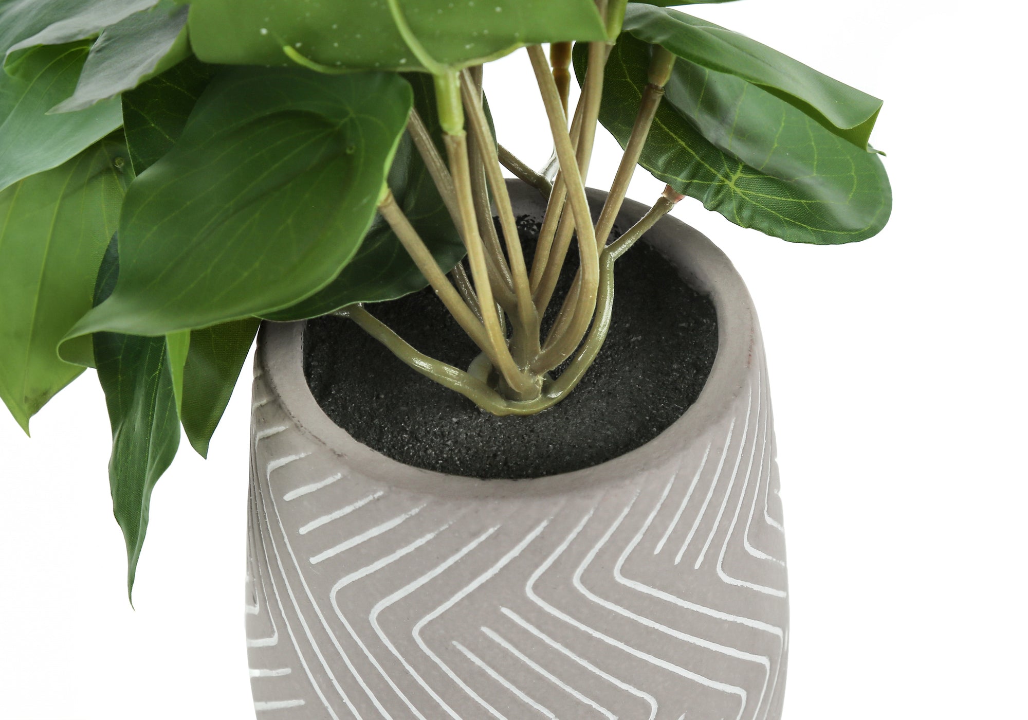 Close-up of an artificial plant with green leaves in a grey textured pot with white geometric line patterns.