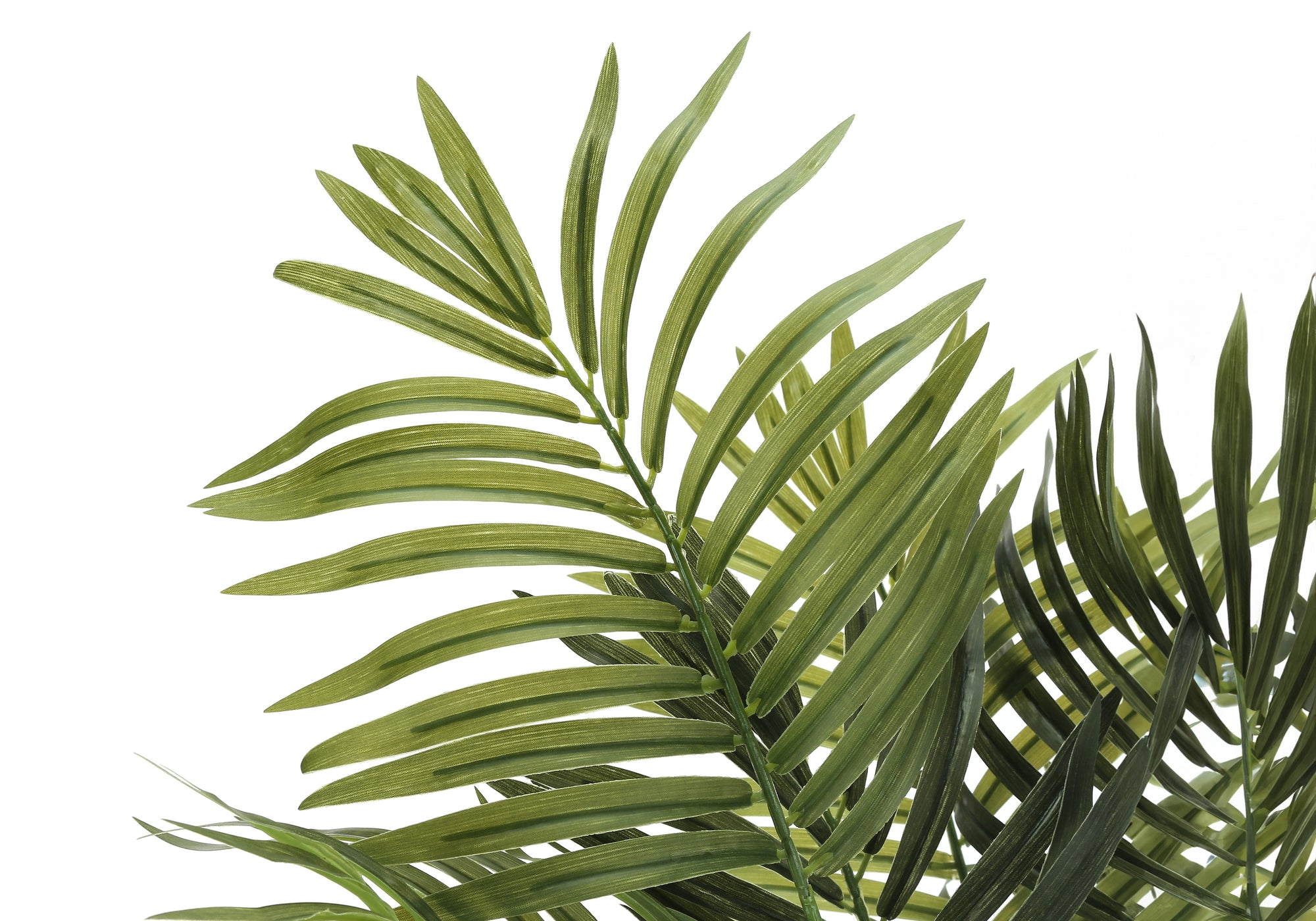 Close-up of feathery green fronds on a faux Areca palm tree against a white background.