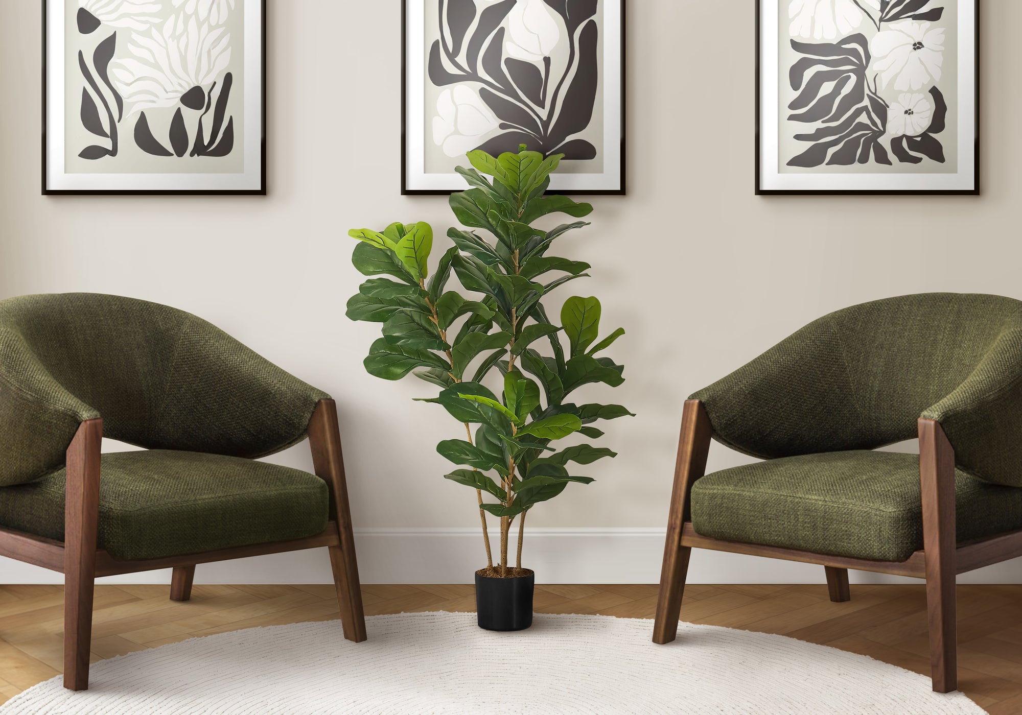 Artificial fiddle leaf fig bush in a black pot centered between two olive green armchairs against a neutral wall.