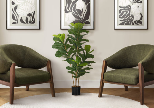 Artificial fiddle leaf fig bush in a black pot centered between two olive green armchairs against a neutral wall.