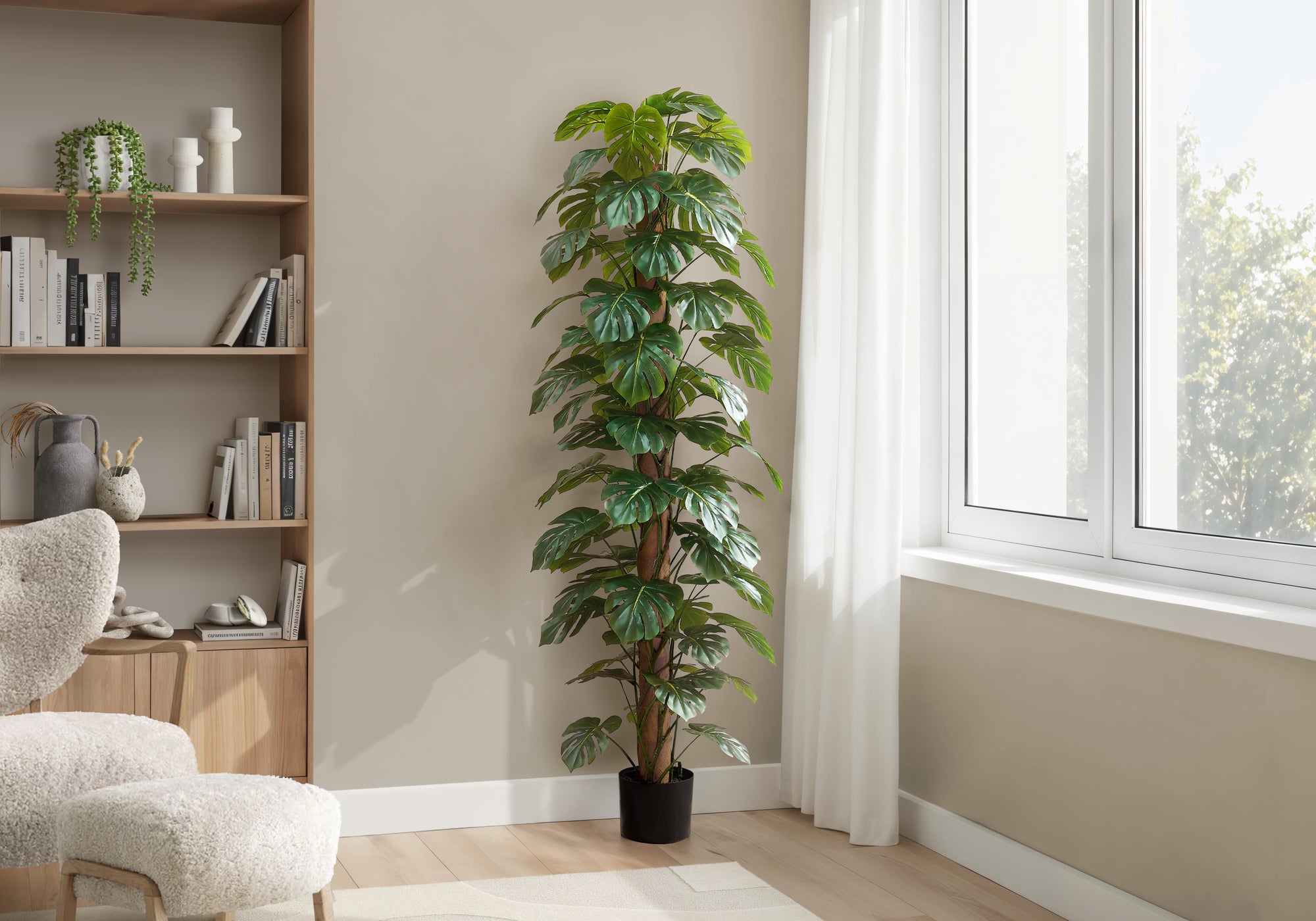 Tall artificial Monstera plant with split leaves climbing a central moss pole in a bright living room corner.